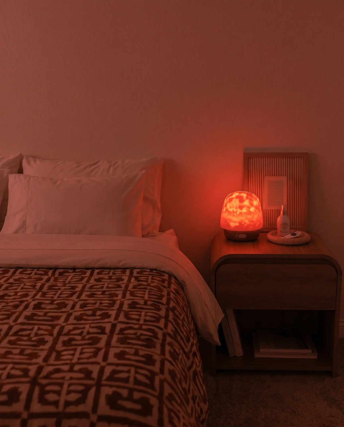 The same bedroom lit only by warm light from Hush Halo