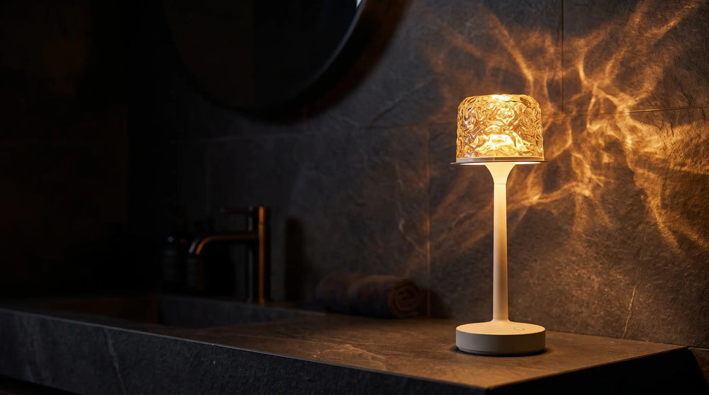 Hush Ember lamp glowing warm amber on a dark bathroom ledge