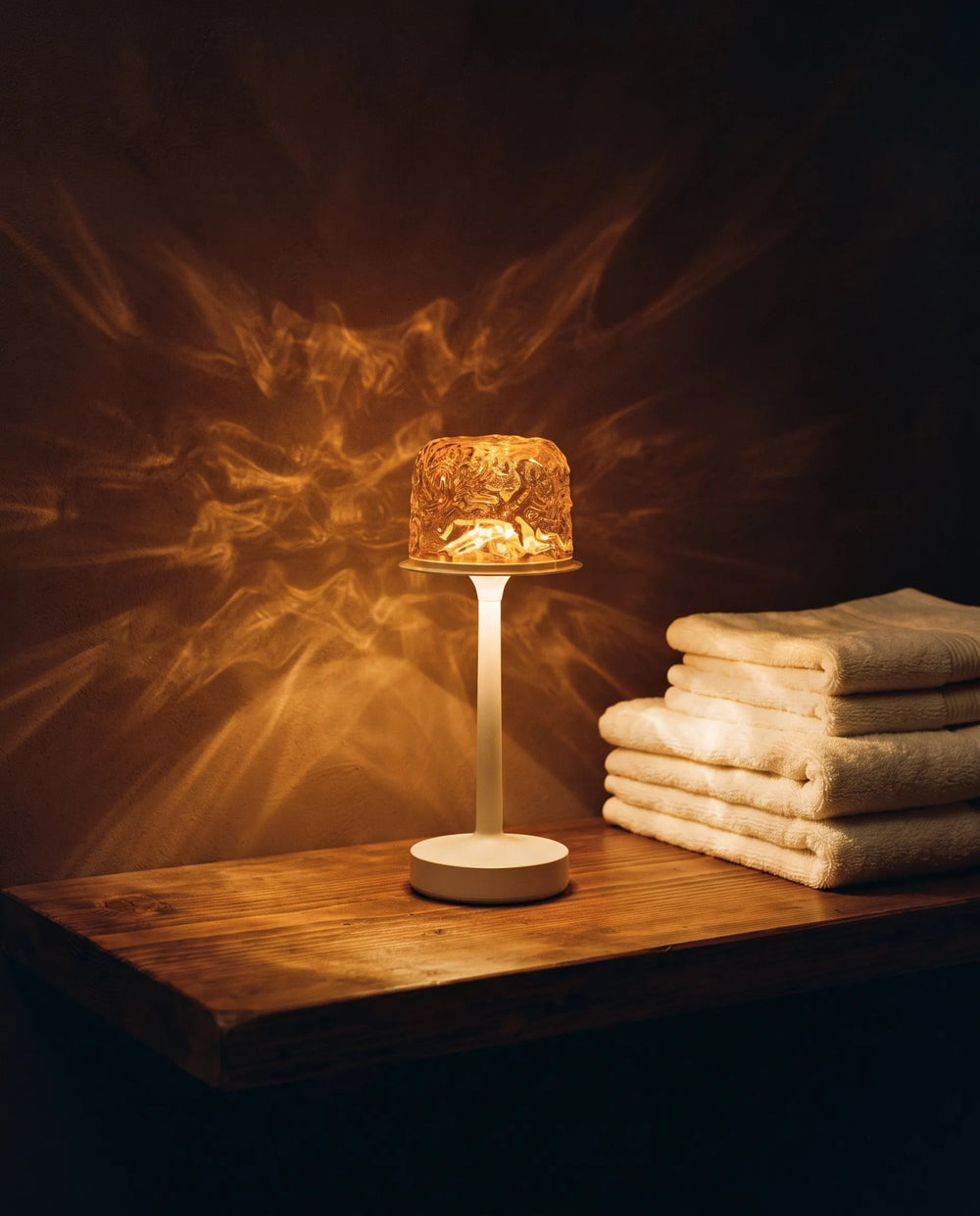 Warm amber light beside folded towels